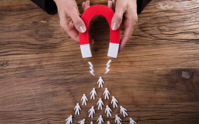 An image of a women holding a magnet and attracting small paper cut outs of customers.