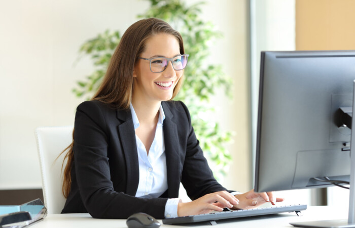An insurance agent taking notes on a computer.