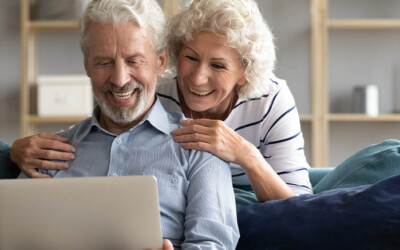 Elderly couple reviewing insurance options online.