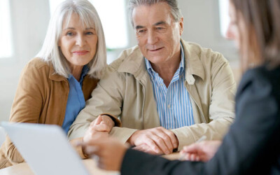 Female insurance agent talking with clients about policy options.