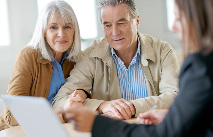 Female insurance agent talking with clients about policy options.