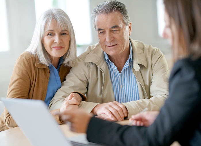 Female insurance agent talking with clients about policy options.