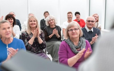 Seminar audience clapping together for host.