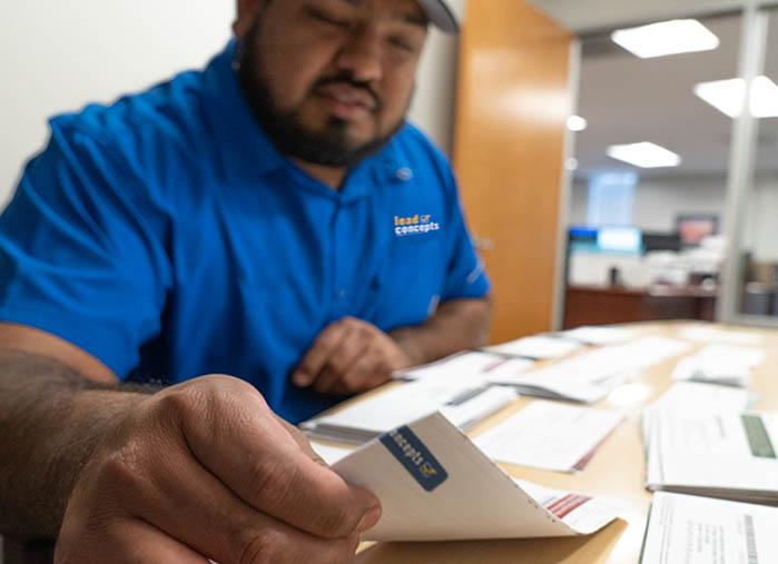 Image of a Lead Concepts employee organizing exclusive direct mail insurance leads.