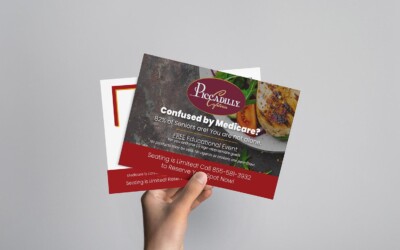 Image of a hand holding two seminar marketing mailers.