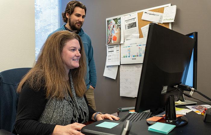 Image of two Lead Concepts employees working together on a direct mail marketing campaign.