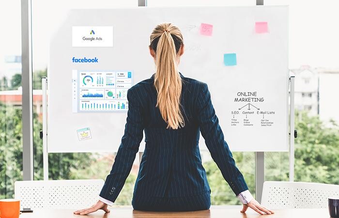 Female professional looking at a white board, designing her insurance marketing campaign.