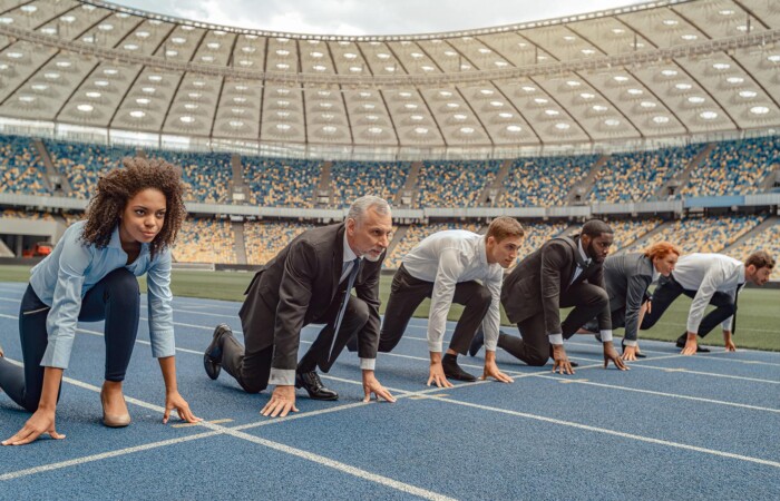 A group of insurance marketing professionals getting ready to run a race on a track.